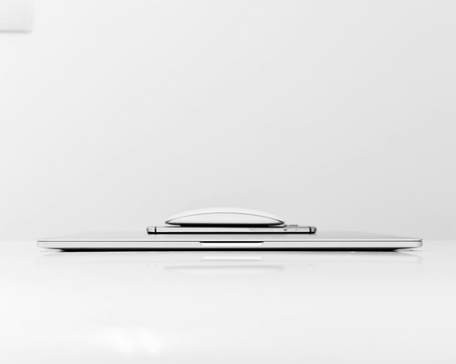 A closed laptop and notebook on a clean white desk