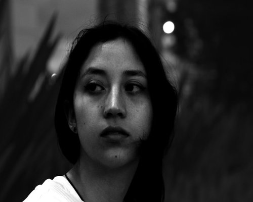 Young woman looking out the window resting her eyes in a Bogota apartment